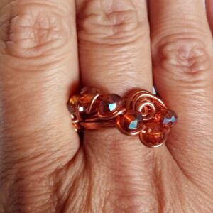 Anello in alluminio rame con cristalli trasparenti arancio. Forma a esse